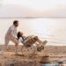 man en vrouw in rolstoel op strand